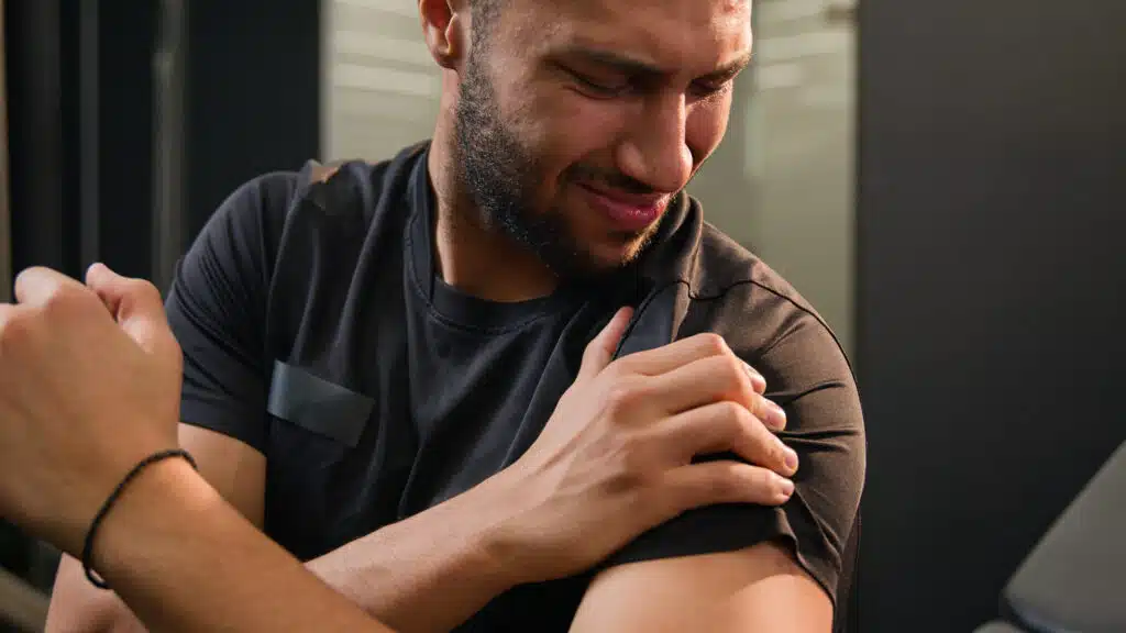 Sporty man holding sore shoulder 1763939