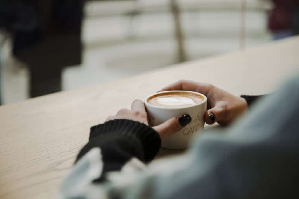 Woman at a cafe drinking coffee 1689276