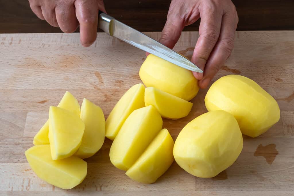 Hands with knife cutting potatoes 1224764